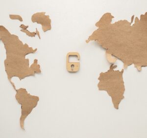 World map made of paper scraps with an open padlock in the center