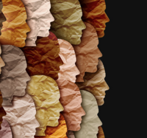 Paper silhouettes in various skin tones overlap and face a single direction on a black background